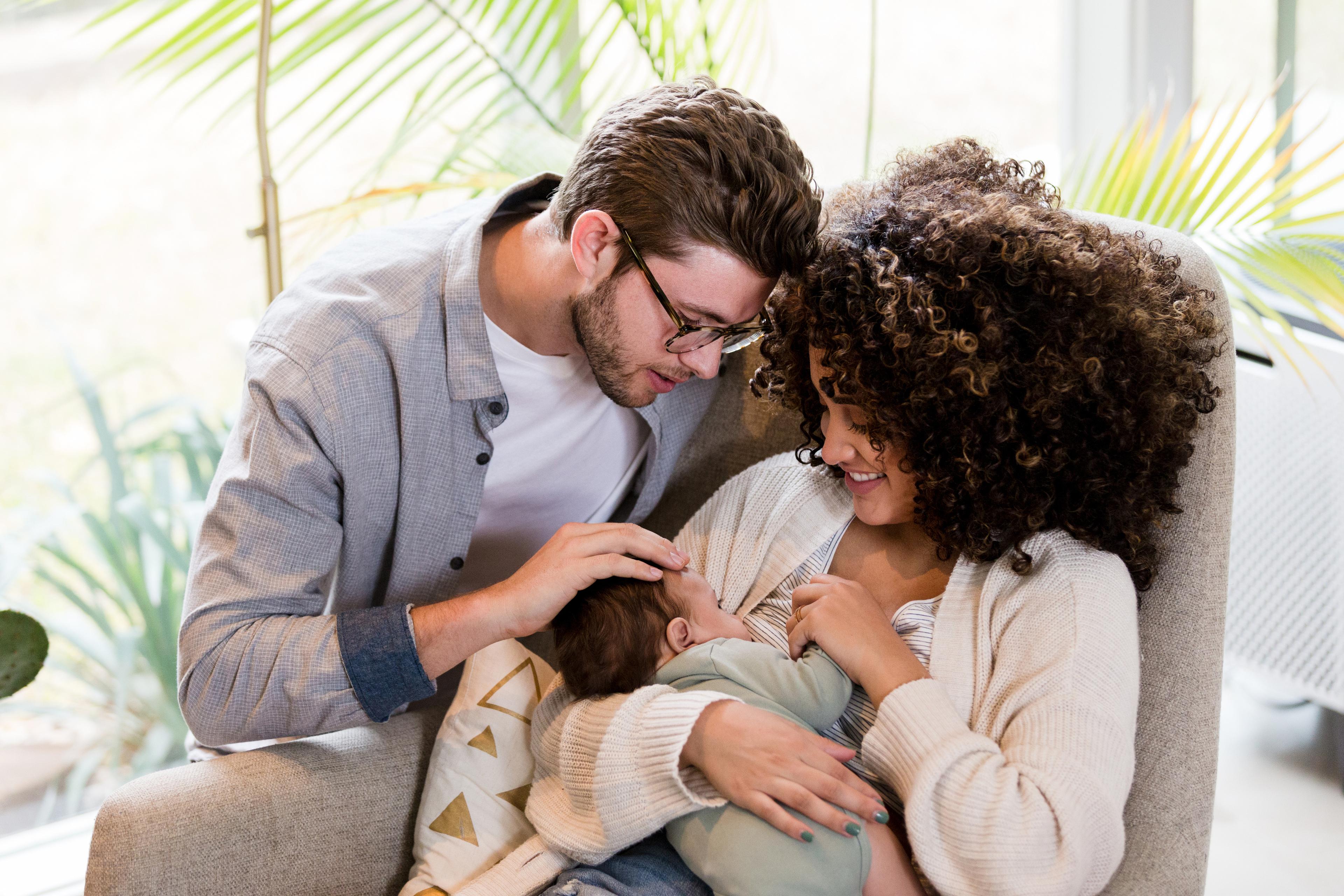 Image of a father and mother hugging their child