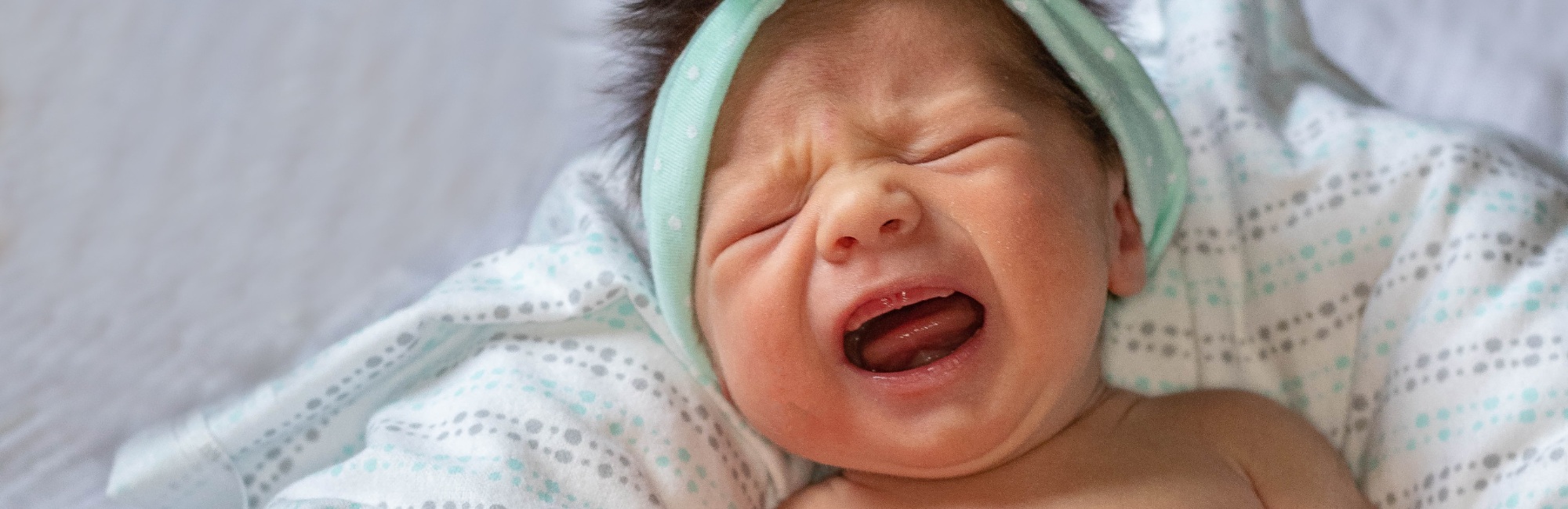 baby in headband crying