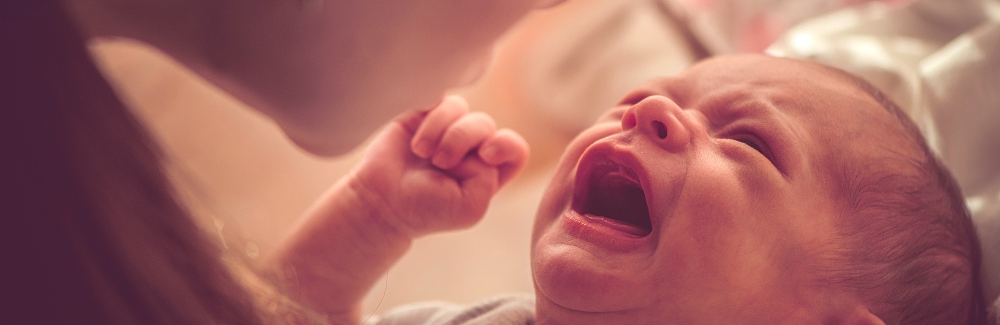 baby crying as mother holds them up