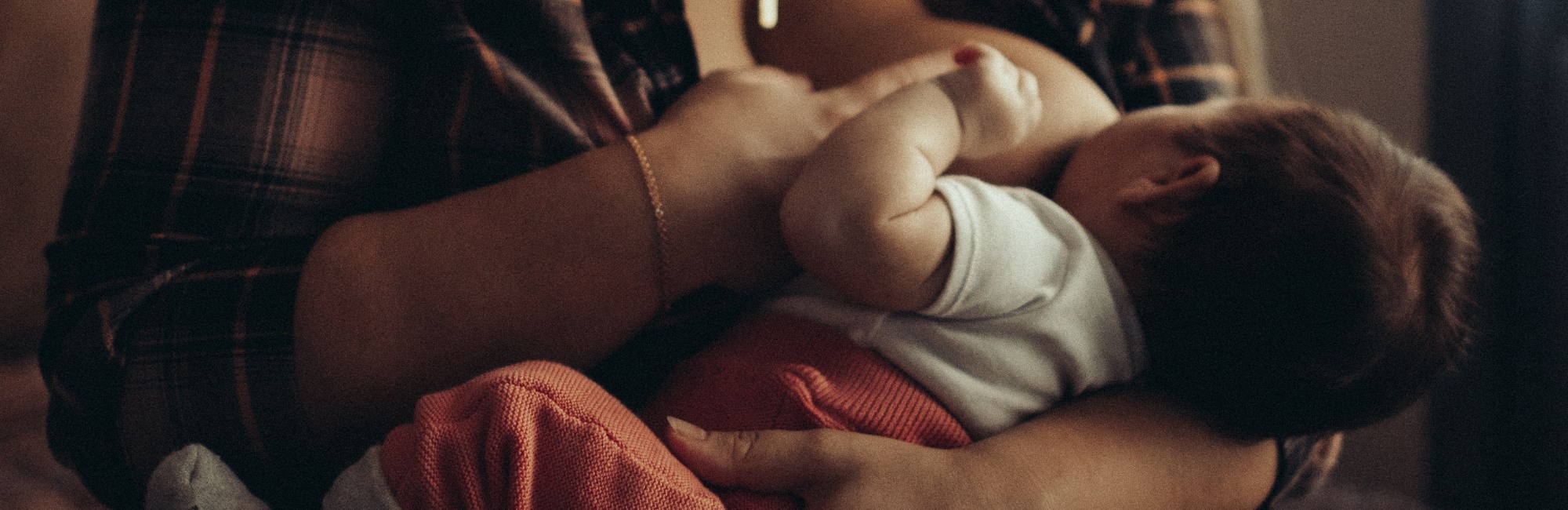 baby with orange pants breastfeeding