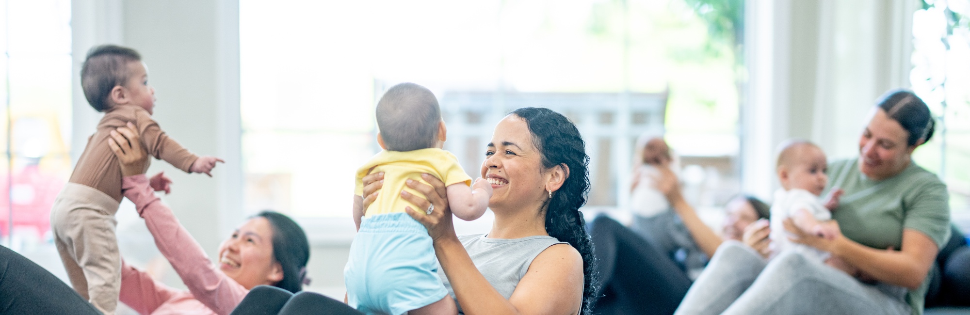 mothers and babies engage in playful exercises together