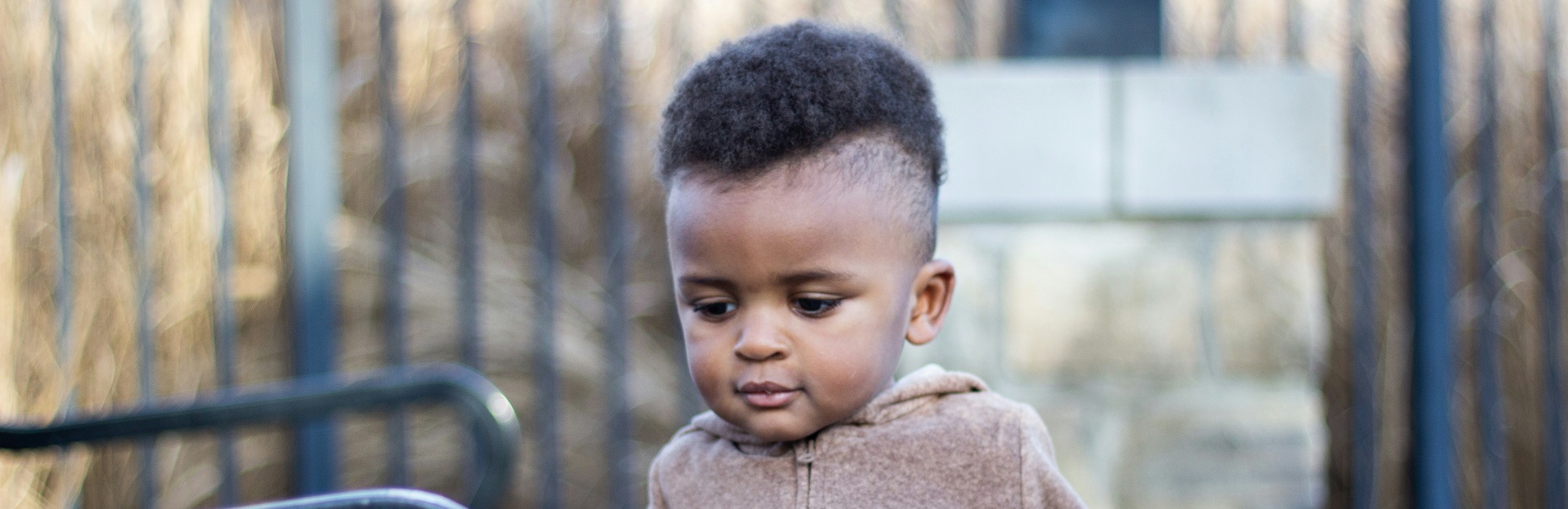 dark skinned toddler with mohawk outside