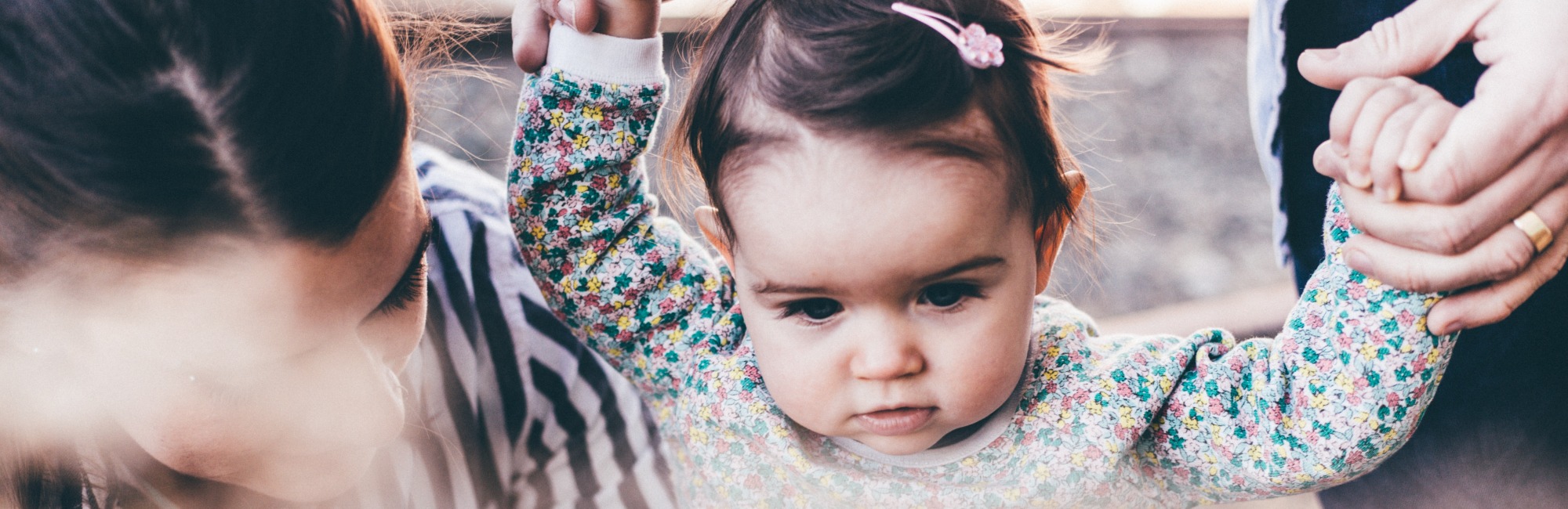 toddler outside holding hands with parent