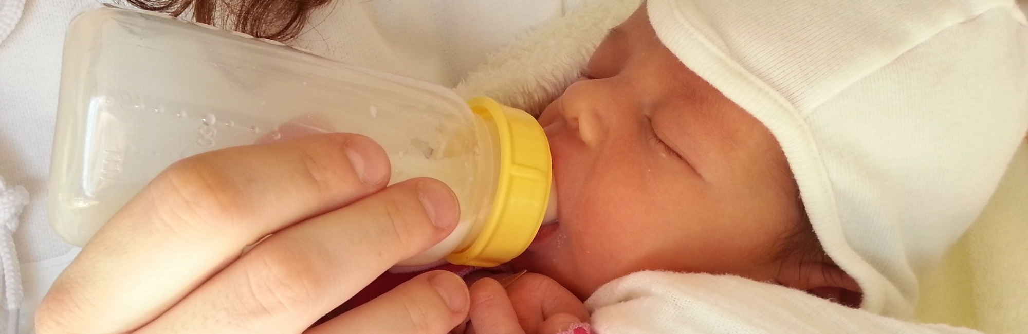 baby happily bottle feeding