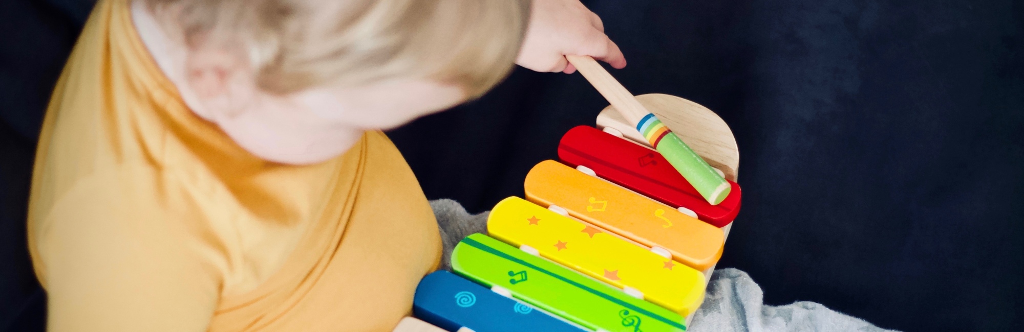 toddler plays with xylophone