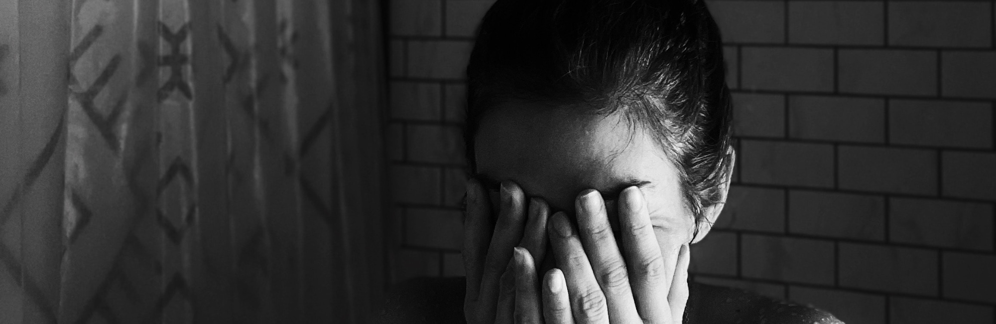 black and white photo of woman with her face in her hands