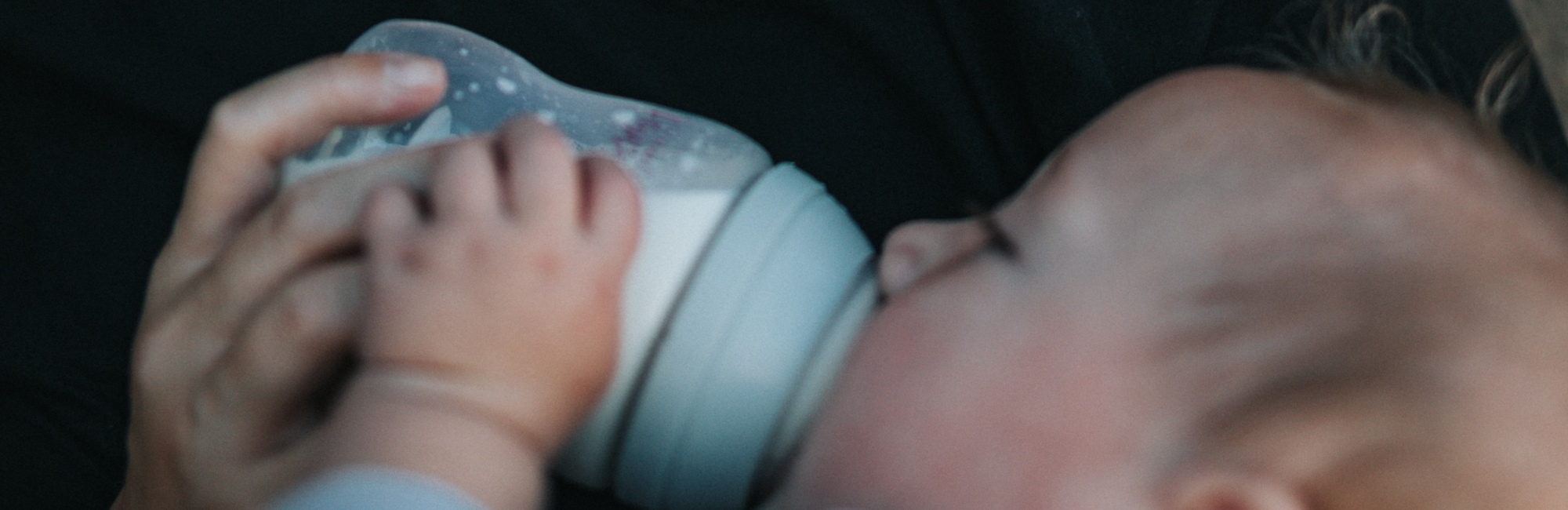 baby being bottle fed by parent