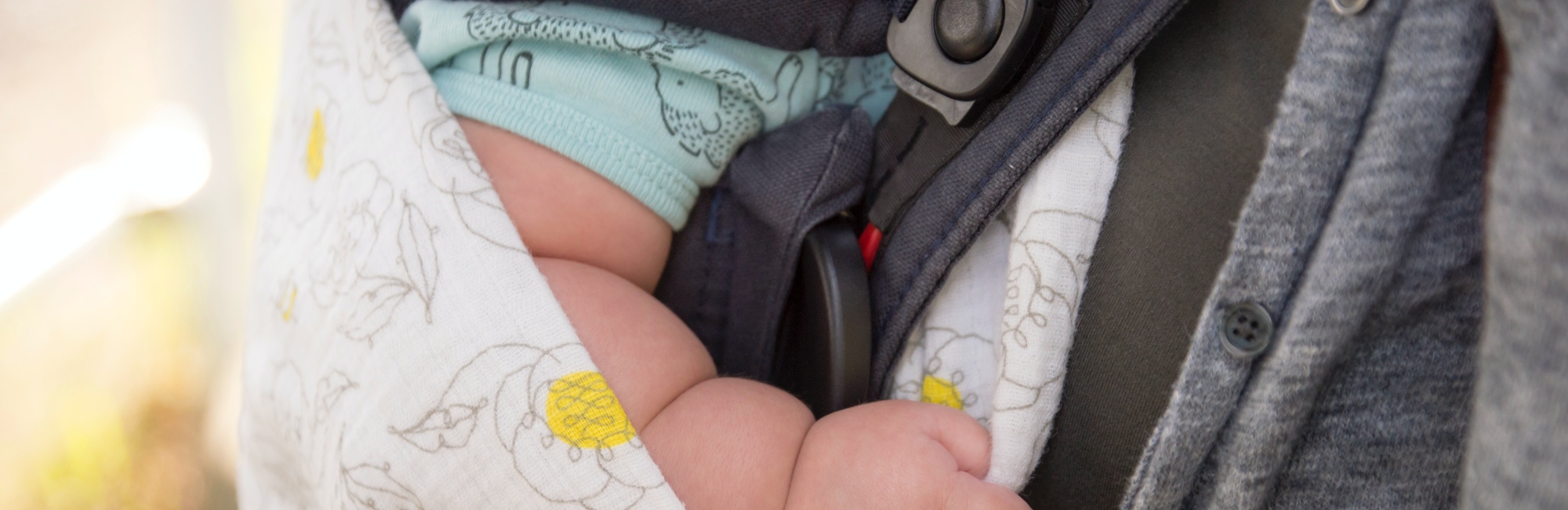 plump baby asleep in carrier