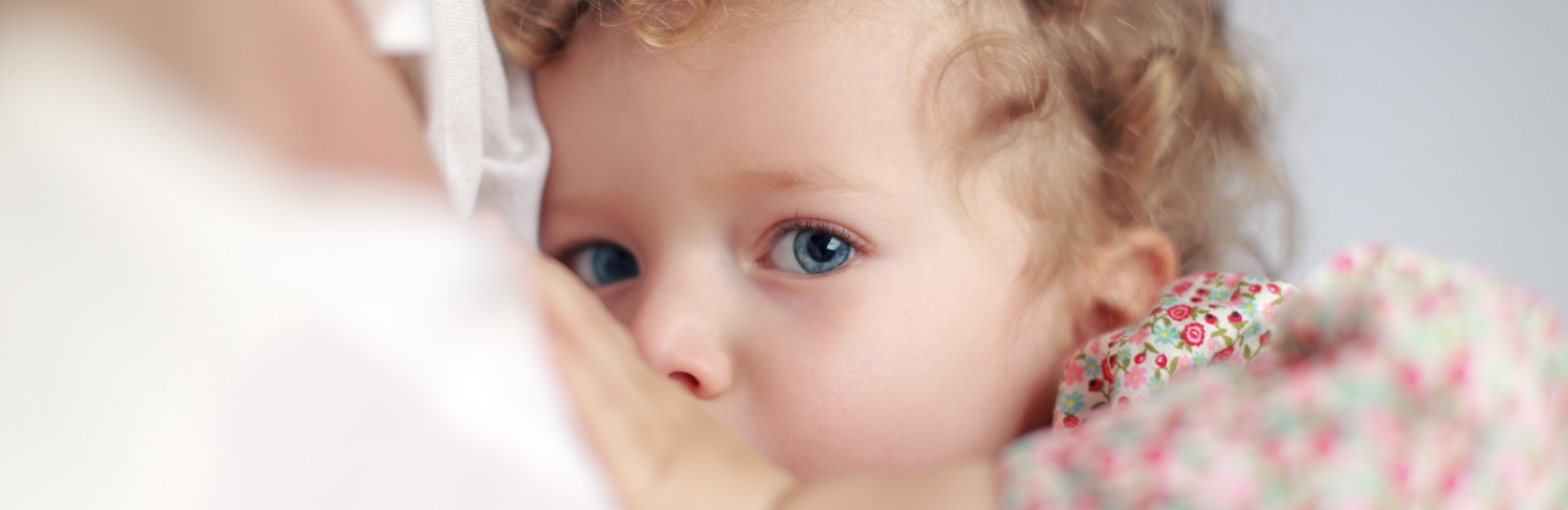 blue eyed breastfeeding baby caucasian girl