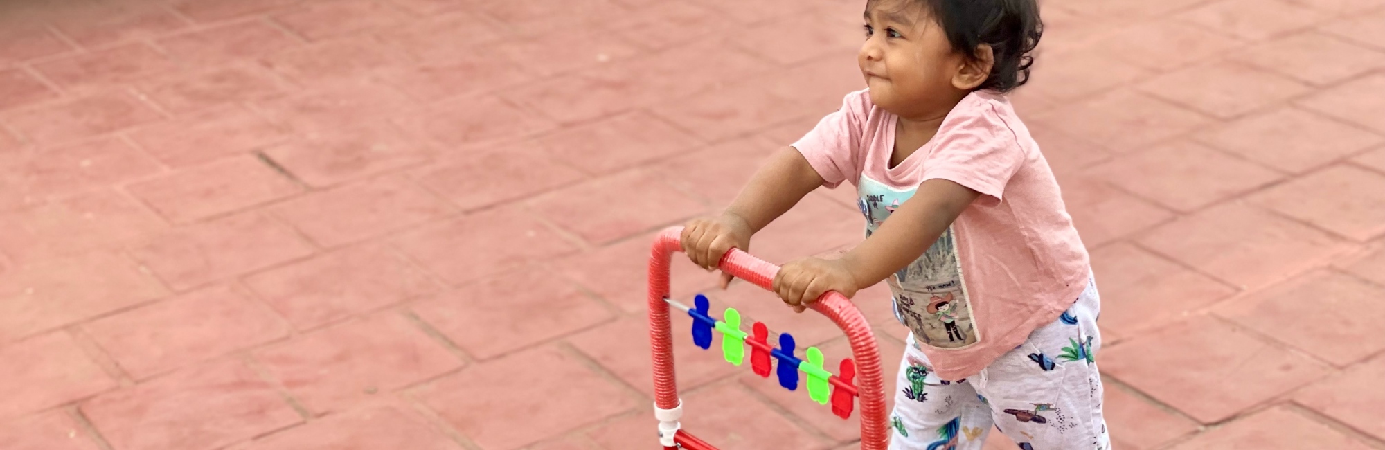 young child playing outside with toy