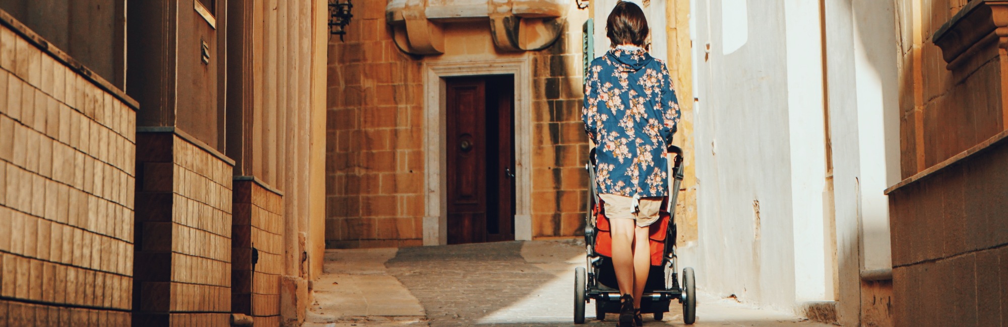 woman pushing pram up a steep path