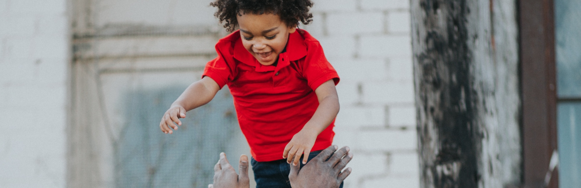 dad playfully throws child into the air
