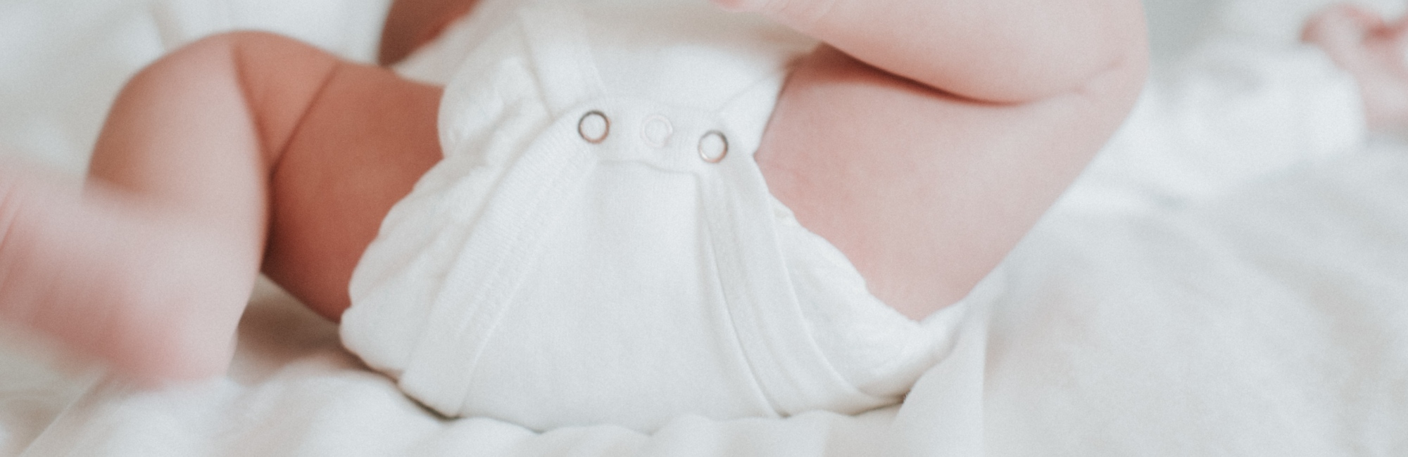 baby with full diaper on bed