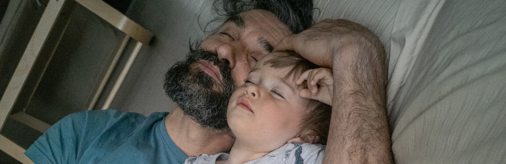 bearded father sleeping with toddler