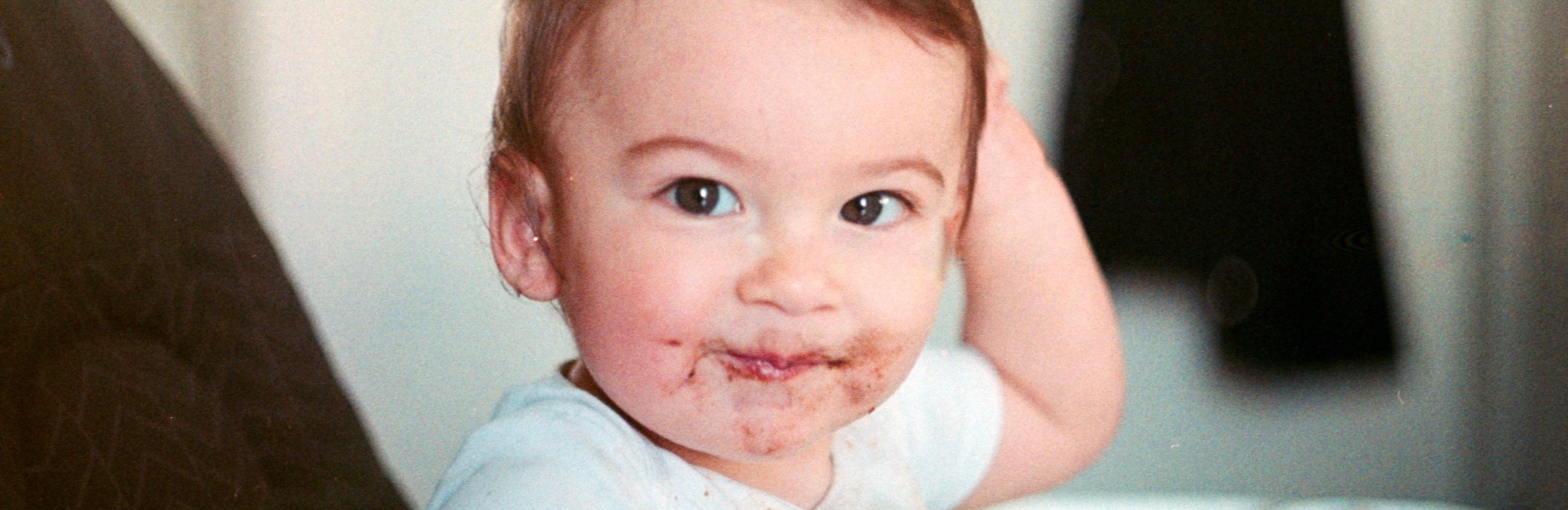 toddler smiling with chocolate around its mouth