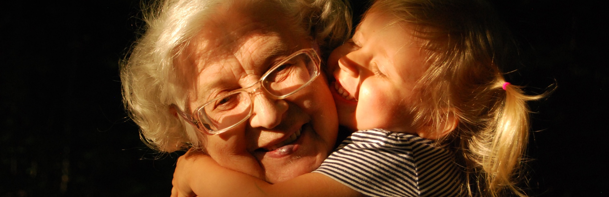 smiling grandma being hugged by smiling child