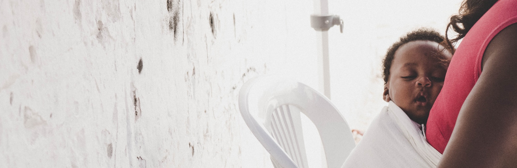 baby sleeps on mothers chest in carrier